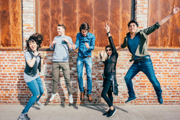 Naklejka premium Group of young beautiful multiethnic man and woman friends having fun jumping outdoor in the city - happiness, friendship, teamwork concept
