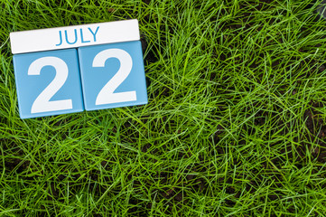 July 22nd. Image of july 22 wooden color calendar on greengrass lawn background. Summer day, empty space for text