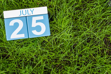 July 25th. Image of july 25 wooden color calendar on greengrass lawn background. Summer day, empty space for text