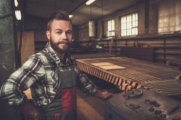 Carpenter doing his job in carpentry workshop.