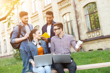 Cute four friends are relaxing near university