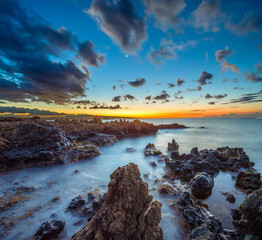 Beautiful and colorful sea sunset near the rocks