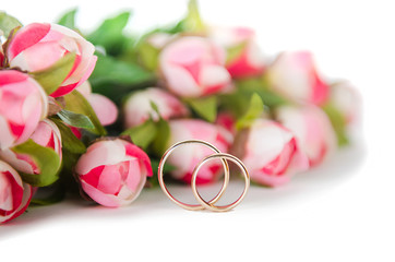 Wedding rings and flowers isolated on white background