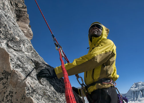 Nepal, Himalaya, Solo Khumbu, Everest region Ama Dablam, mountaineer with rope at rock face looking up