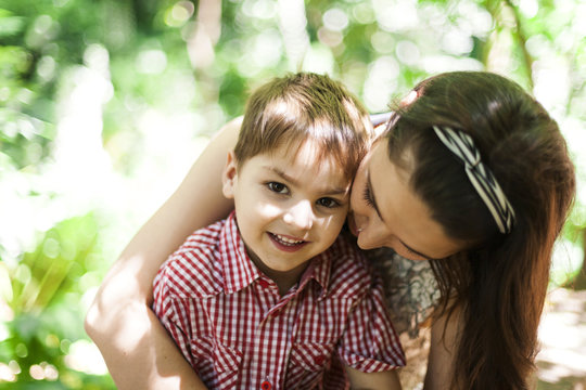 Portrait of happy little boy with his mother in nature