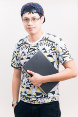 Handsome asian man smiling looking at camera and holding laptop
