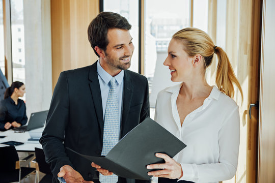 Businessman and businesswoman talking in office