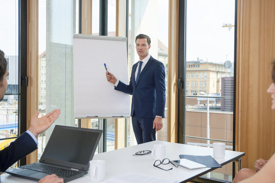 Businessman leading a presentation at flip chart