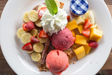 Waffle with ice-cream, banana, strawberry and mango