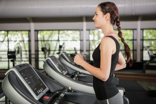 Happy woman jogging on treadmill