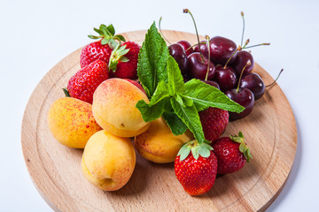 fruits and berries on a wooden cutting board