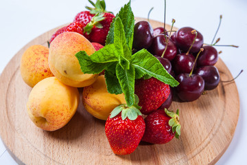 fruits and berries on a wooden cutting board