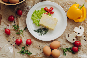 Omelet with ham on parchment background. Vegetable composition. Flat lay