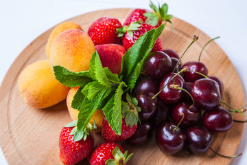 fruits and berries on a wooden cutting board