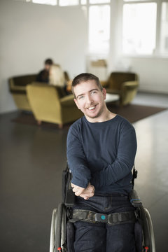 Young smiling man sitting in wheelchair