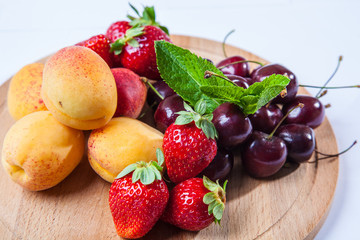 fruits and berries on a wooden cutting board