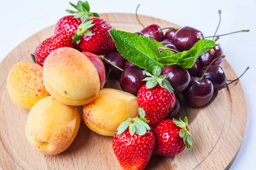 fruits and berries on a wooden cutting board