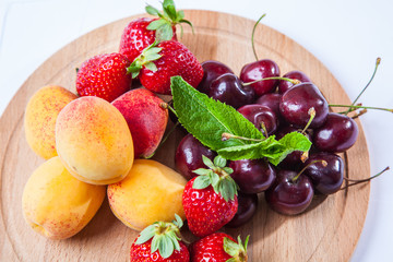 fruits and berries on a wooden cutting board