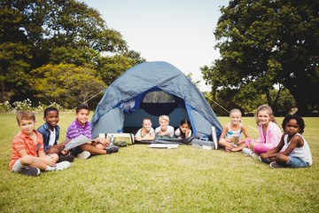  Smiling kids posing in the tent together during a sunny day