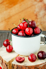 
Summer berries and fruits, ripe red cherry in an iron bowl on a wooden background , rustic style