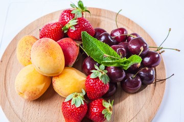 fruits and berries on a wooden cutting board