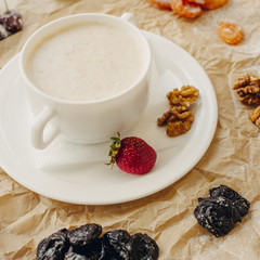 Oat meal with walnuts and berries. Parchment background. Square crop.