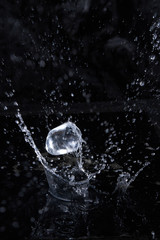 Ice cube flying with splashes on a black background #2
