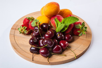 fruits and berries on a wooden cutting board