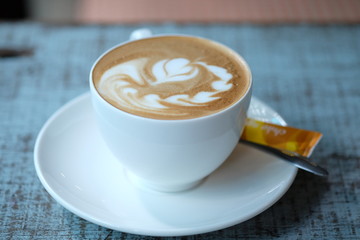 Cup of cappuccino on the wooden table. Close up.