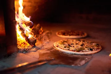 Selbstklebende Fototapeten rohe Pizza legen Ofen mit dem Feuer auf Klinge. © Аrtranq