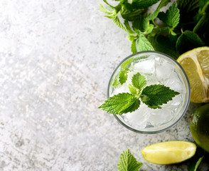 Ingredients for making mojitos (ice cubes, mint leaves, sugar and lime on rustic background)
