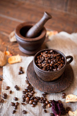 Cup of coffee with beans on wooden table