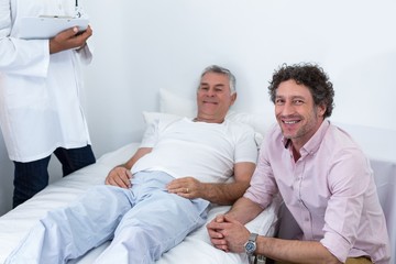 Obraz premium Man sitting next to patient smiling
