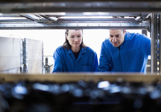 Male and female technicians working in factory