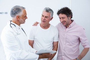 Obraz premium Senior man and his guardian talking to the doctor