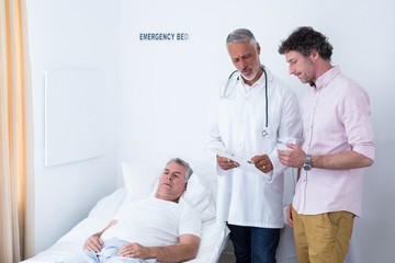 Obraz premium Male doctor discussing medical report with man