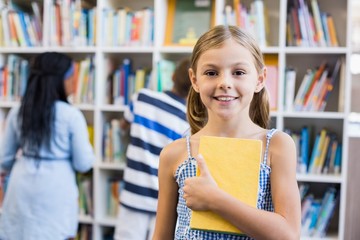 Girl holding a book in library