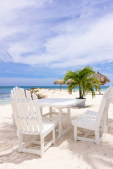 white restaurant table and chairs on the beach