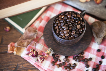 Wooden cup with coffee beans and books