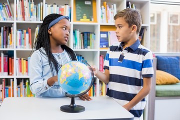 School kids discussing with each other in library 