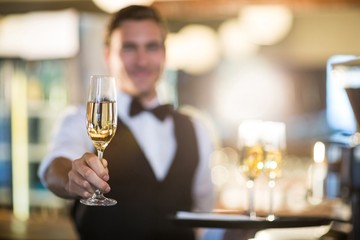 Waiter offering a glass of champagne  - Powered by Adobe