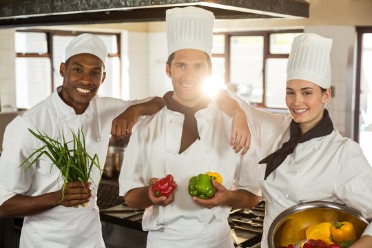 Portrait Of Three Chefs Holding A Vegetables