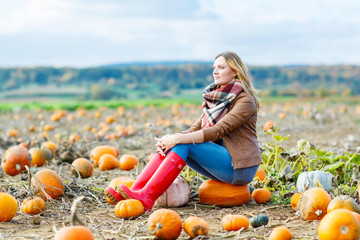 Beautiful woman working on pumpkin field