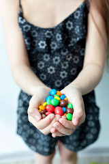 Little girl holding candy in the hands
