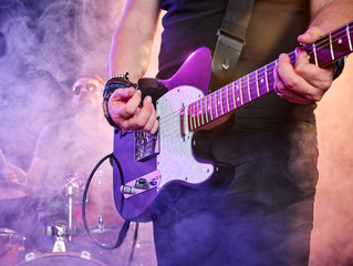 Obraz na płótnie Canvas Rock band performs on stage. Guitarist.