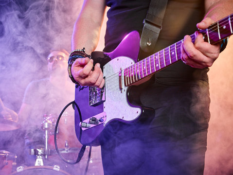 Rock band performs on stage. Guitarist.