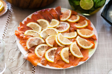 plate with sliced smoked salmon fish with lemon