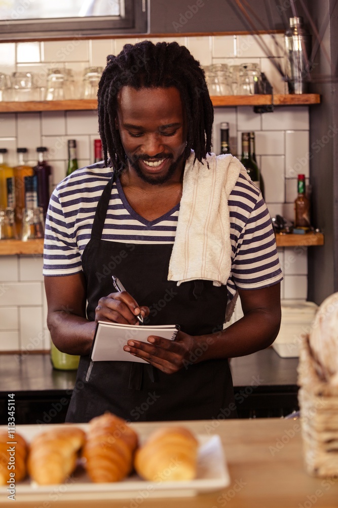 Poster portrait of smiling hipster taking an order at work