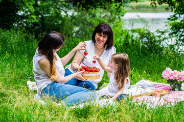 Fototapeta premium grandmother, daughter and granddaughter on a picnic