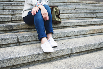 Woman in jeans with sitting on the stairs